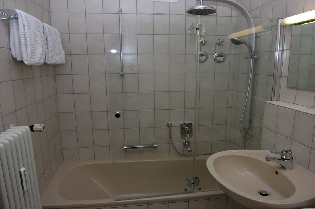 Bad mit Wanne und Komfort-Duschsäule, 
Glasduschwand mit Tür